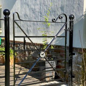 Gate with scroll work and dog motif